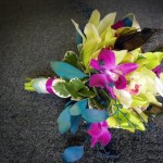 Dramatic Orchid bridesmaid bouquet with peacock feathers.