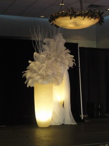 Lit stands with feather plume arrangements for stage display.