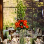 Exotic centerpiece of oversized orange flowers, green Bells of Ireland, and Tea Leaves. Fun and dramatic.