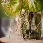 Strands of raffia and delicate pearls add rustic charm to Mason jar centerpieces.