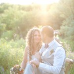 The sunset adds nostalgia and beauty to this shot of the wedding couple and their flowers.