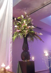 This dramatic floral arrangement looks modern and fresh atop an oversized black glass vase.