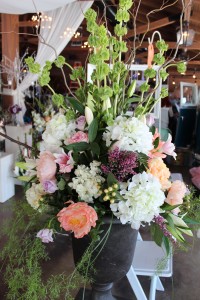 Oversized arrangement of Hydrangea, Bells of Ireland, and Curly Willow in pewter urn.