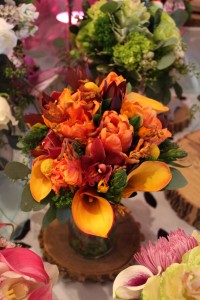 Full of lively colors and texture, this bouquet mixes bright oranges, deep burgandy, and rich greenery.