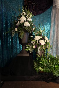 Large urn arrangements in whites and fresh greens for the stage.