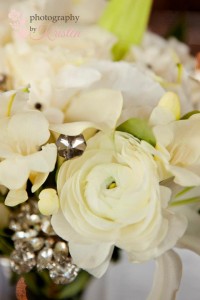 Beautiful all white bouquet of Lillies, Ranunculus, Freesia, and Garden Roses with crystal embellishments. Photo by: Photography by Kristen